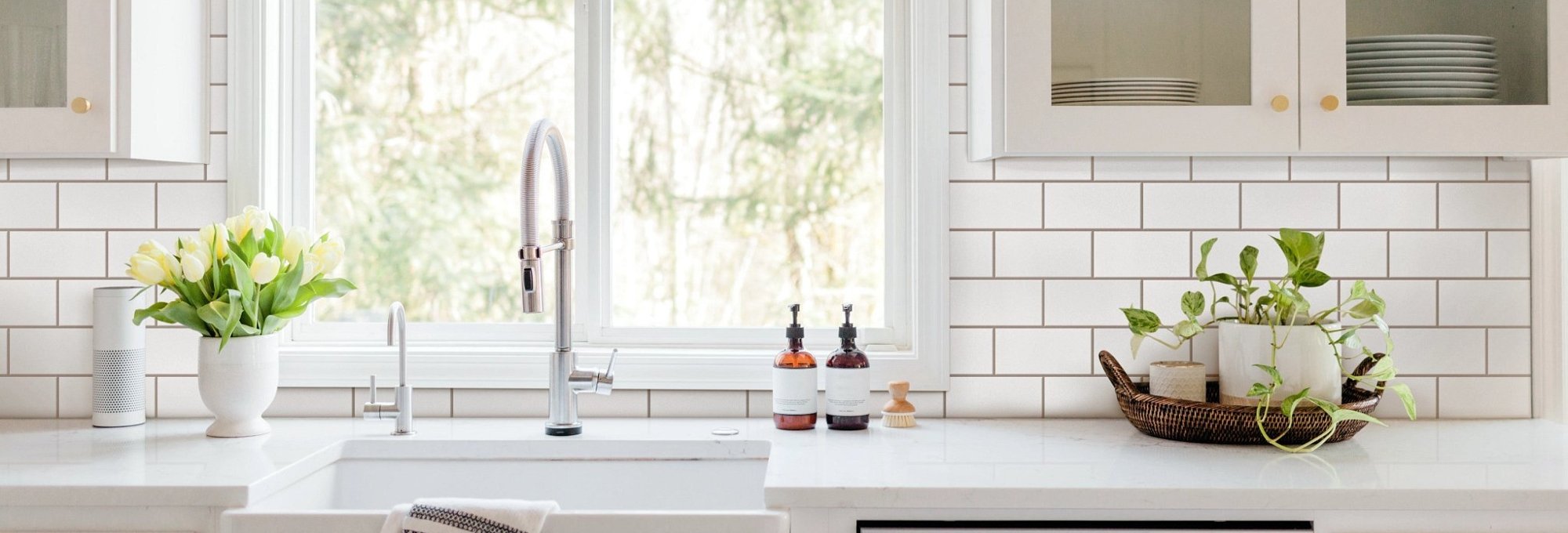 bright kitchen counter with sink and tile backsplash - USA Carpets in GA